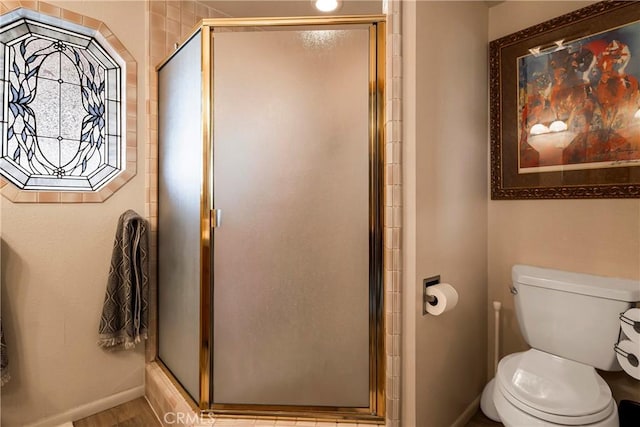 bathroom featuring wood-type flooring, toilet, and an enclosed shower