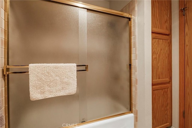 bathroom featuring shower / bath combination with glass door