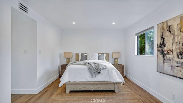 bedroom with visible vents, recessed lighting, baseboards, and wood finished floors