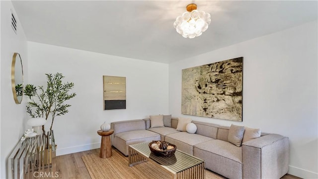 living room featuring an inviting chandelier and wood-type flooring