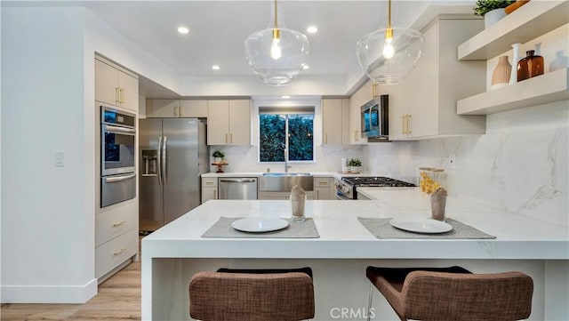 kitchen with a peninsula, stainless steel appliances, light countertops, a warming drawer, and tasteful backsplash