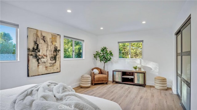 bedroom with recessed lighting, multiple windows, baseboards, and wood finished floors