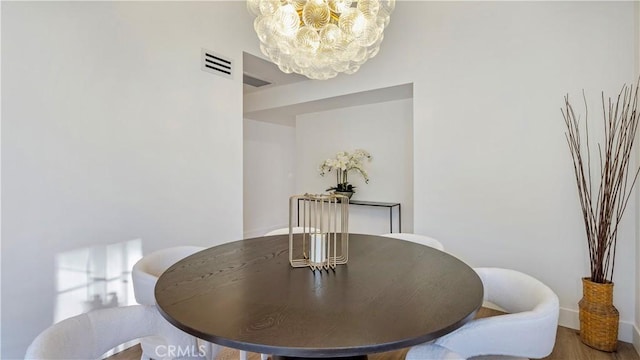 dining area featuring a notable chandelier and hardwood / wood-style flooring