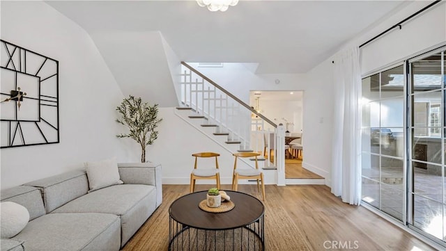 living room with stairs, baseboards, and wood finished floors