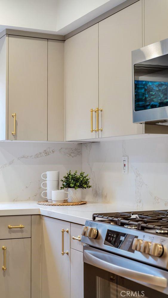 kitchen featuring backsplash, appliances with stainless steel finishes, and light countertops