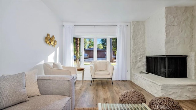 living room featuring light hardwood / wood-style flooring and a large fireplace