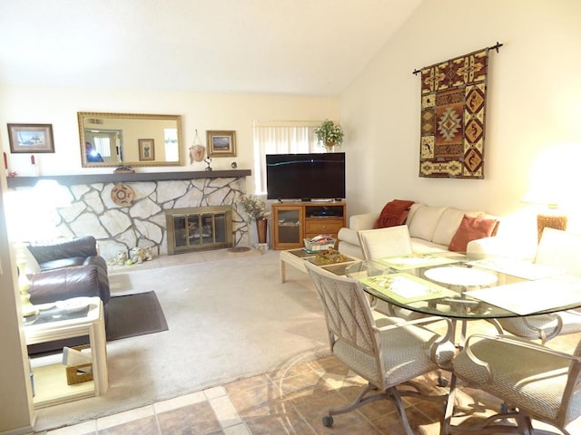 living room featuring lofted ceiling, carpet floors, and a fireplace