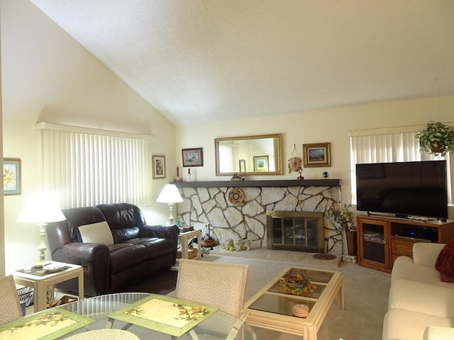 living room with a stone fireplace, plenty of natural light, high vaulted ceiling, and carpet flooring