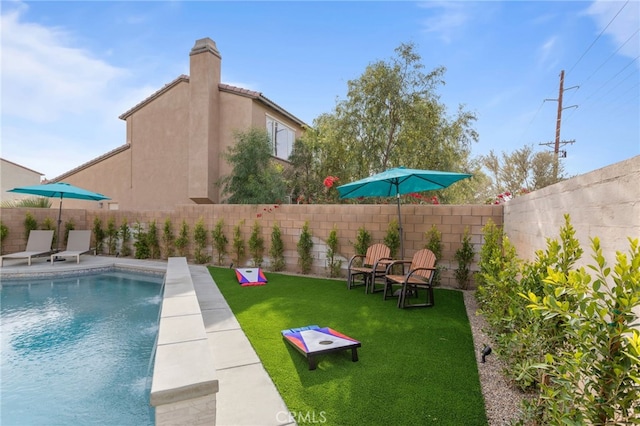 view of swimming pool featuring a yard