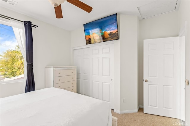 carpeted bedroom with ceiling fan, a closet, and multiple windows