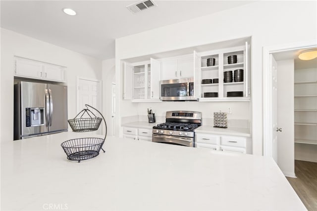 kitchen featuring appliances with stainless steel finishes, wood-type flooring, and white cabinets