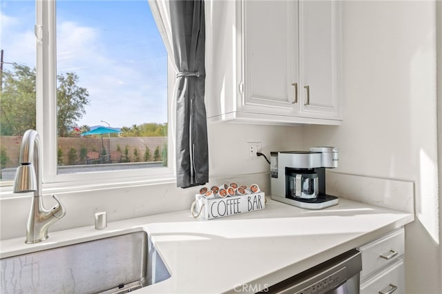 kitchen featuring stainless steel dishwasher and white cabinets