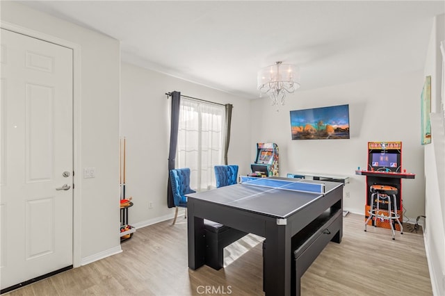 recreation room featuring a notable chandelier and light hardwood / wood-style floors