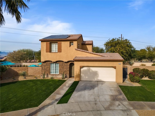 mediterranean / spanish home featuring a garage, a front lawn, and solar panels