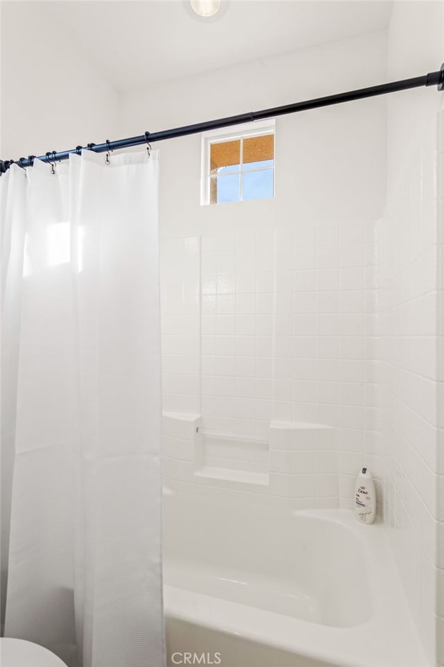 bathroom with shower / bath combo with shower curtain