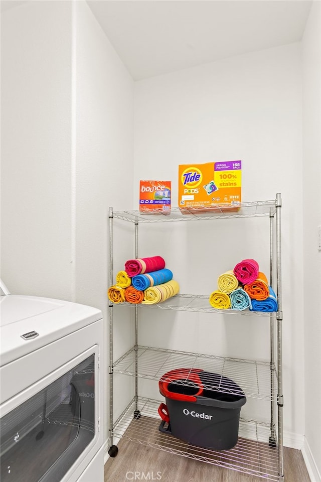 clothes washing area featuring washer / clothes dryer and hardwood / wood-style flooring