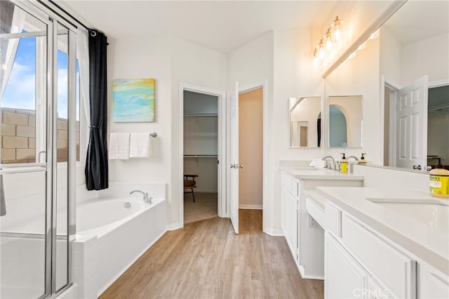 bathroom featuring vanity, wood-type flooring, and shower with separate bathtub