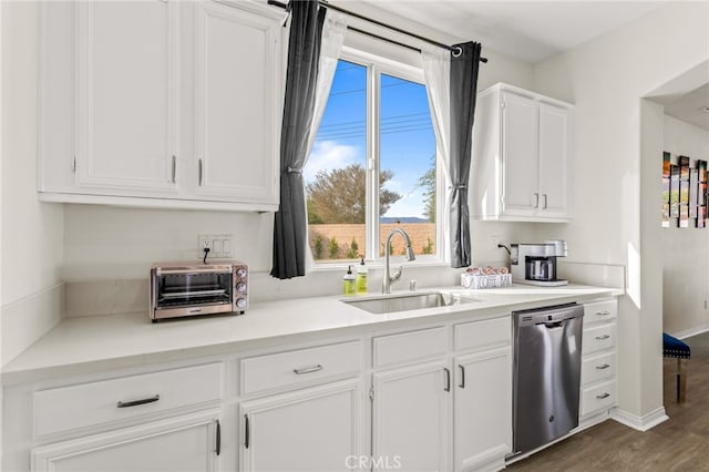 kitchen featuring sink, stainless steel dishwasher, white cabinets, and dark wood-type flooring