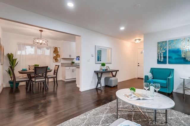 living room featuring dark wood-type flooring and a chandelier