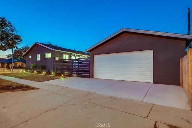 property exterior at dusk with a garage and an outdoor structure