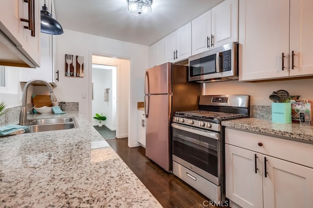 kitchen featuring white cabinetry, sink, light stone counters, and appliances with stainless steel finishes