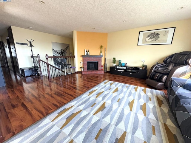 living room featuring hardwood / wood-style flooring, a fireplace, and a textured ceiling