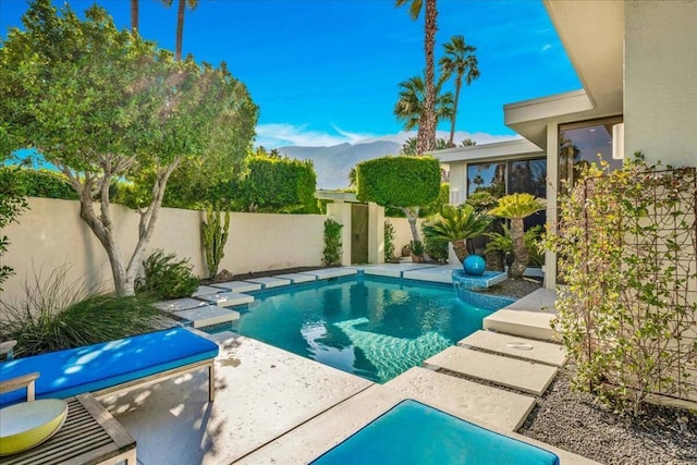 view of swimming pool featuring a mountain view and a patio area