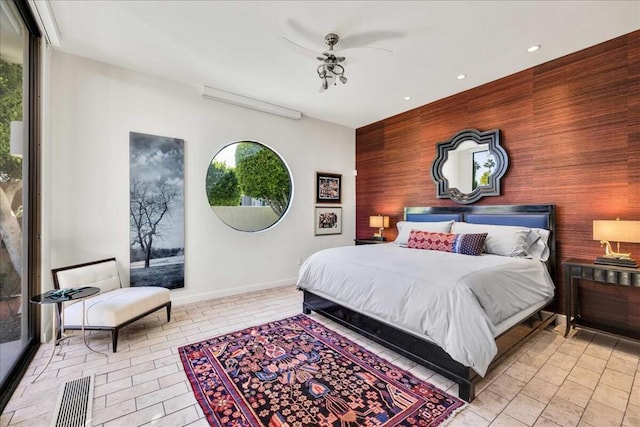 bedroom with multiple windows and wood walls