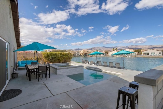 view of pool with an outdoor living space, a jacuzzi, a patio area, and a water and mountain view