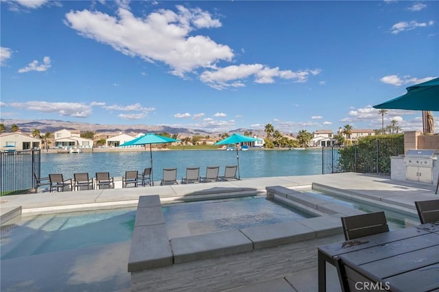 view of swimming pool featuring an in ground hot tub, area for grilling, a patio area, and a water and mountain view