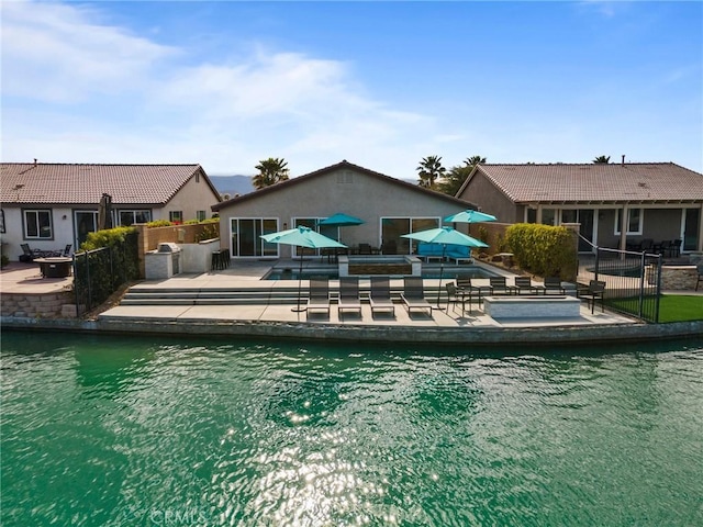 view of pool with a water view and a patio