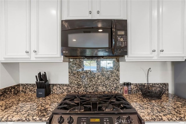 kitchen featuring white cabinetry, dark stone countertops, and range with gas stovetop