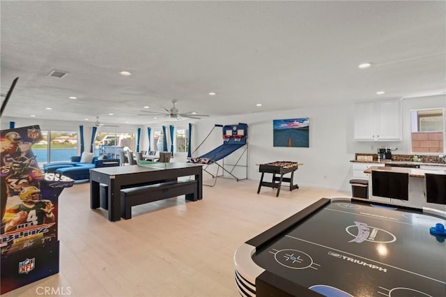 recreation room featuring light hardwood / wood-style floors and ceiling fan