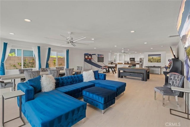 living room featuring ceiling fan and light wood-type flooring