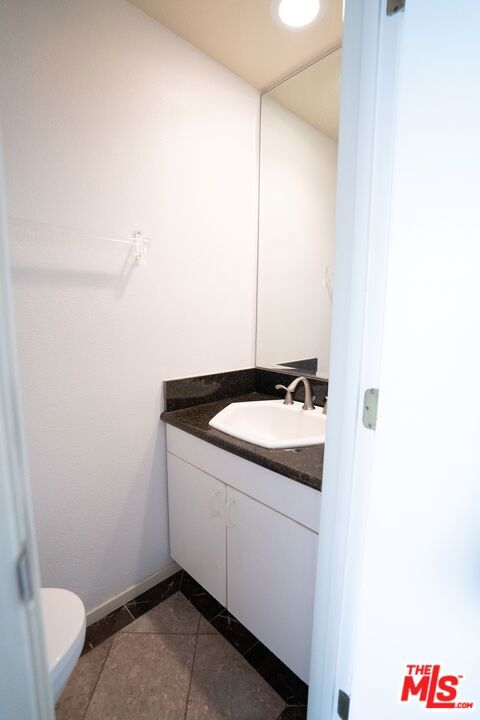 bathroom with vanity, tile patterned floors, and toilet