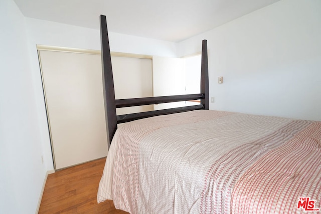 bedroom with hardwood / wood-style floors and a closet