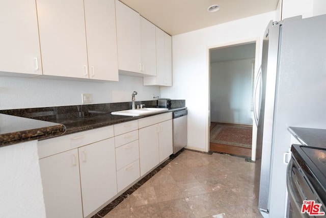 kitchen with white cabinetry, sink, dark stone counters, and appliances with stainless steel finishes