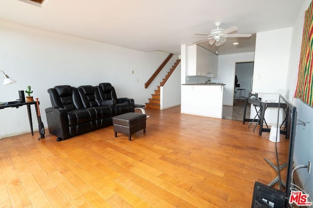 living room featuring ceiling fan and light hardwood / wood-style flooring