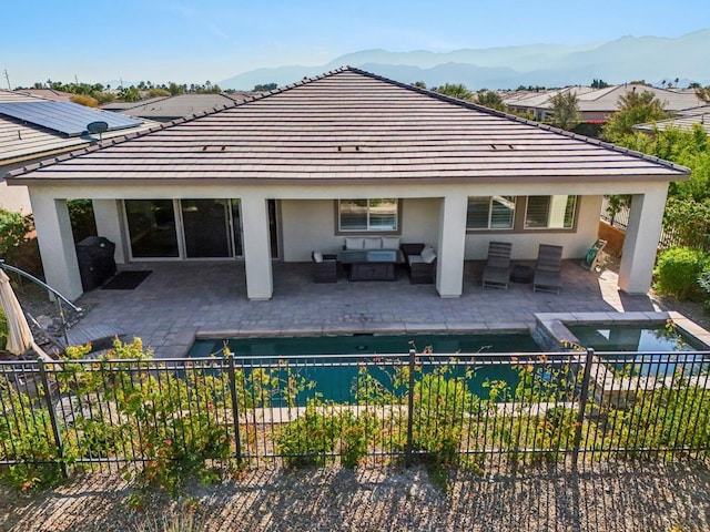 back of property with an outdoor living space, a patio, and a mountain view