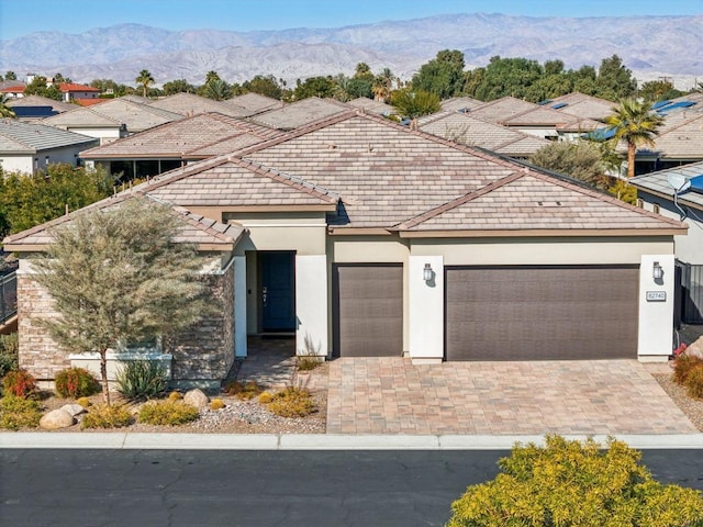 view of front of home with a garage and a mountain view