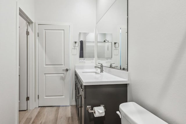 bathroom featuring vanity, toilet, and hardwood / wood-style floors