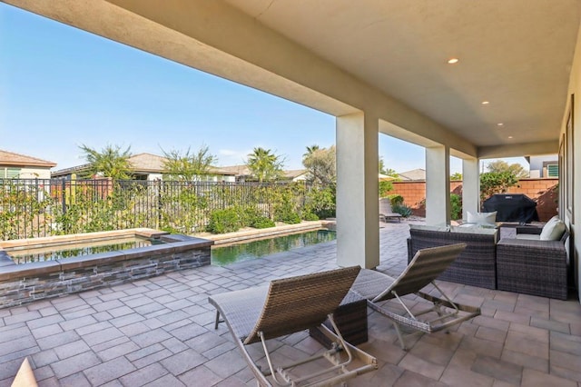 view of patio / terrace featuring a grill, outdoor lounge area, and an in ground hot tub