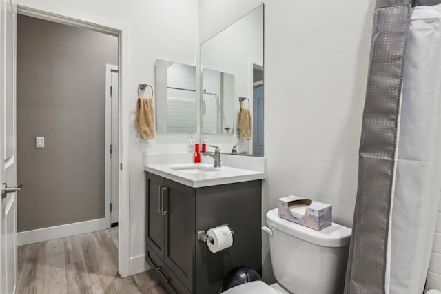 bathroom featuring wood-type flooring, vanity, and toilet