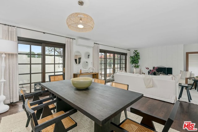 dining space with french doors, a wall mounted air conditioner, and wood-type flooring