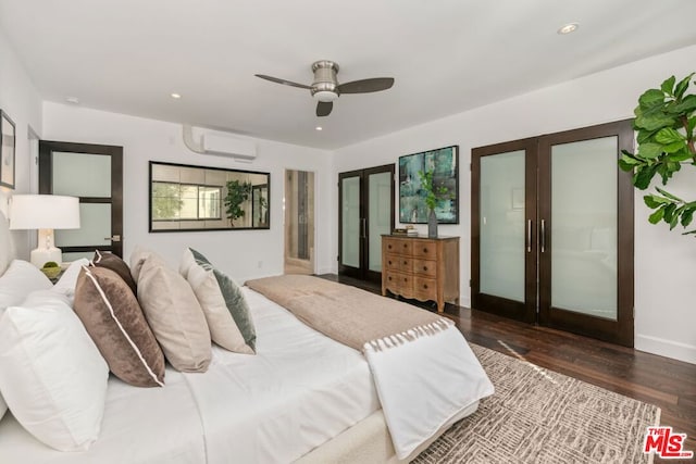 bedroom with ceiling fan, a wall mounted AC, dark hardwood / wood-style flooring, and french doors