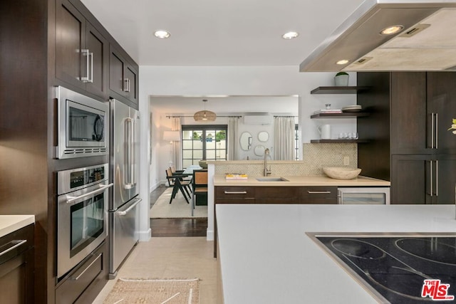 kitchen with appliances with stainless steel finishes, sink, decorative backsplash, dark brown cabinets, and a wall unit AC