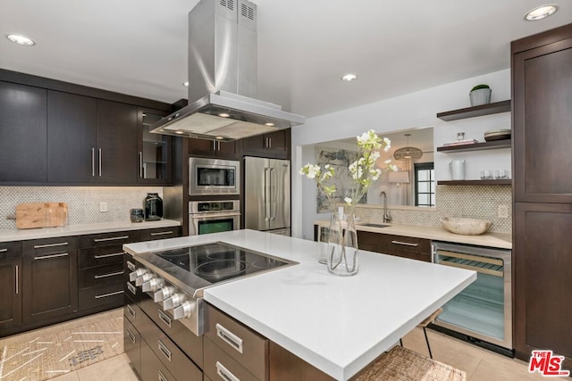 kitchen featuring stainless steel appliances, a center island, wine cooler, tasteful backsplash, and island exhaust hood