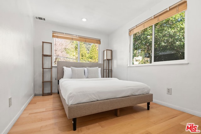 bedroom featuring multiple windows and light wood-type flooring