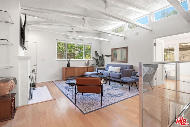 living room with light hardwood / wood-style flooring and beamed ceiling