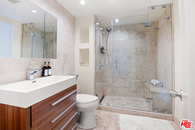 bathroom with vanity, backsplash, a shower with shower door, and toilet